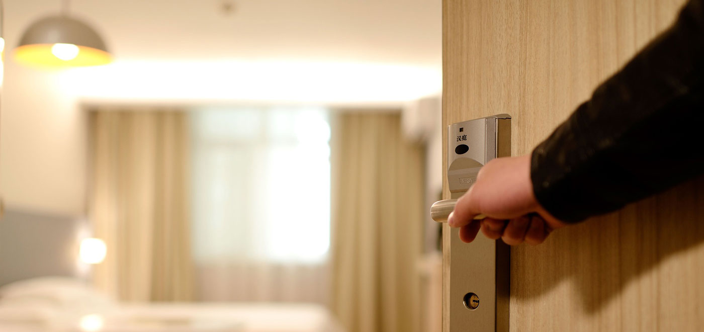 A person opens the door of his comfortable hotel room