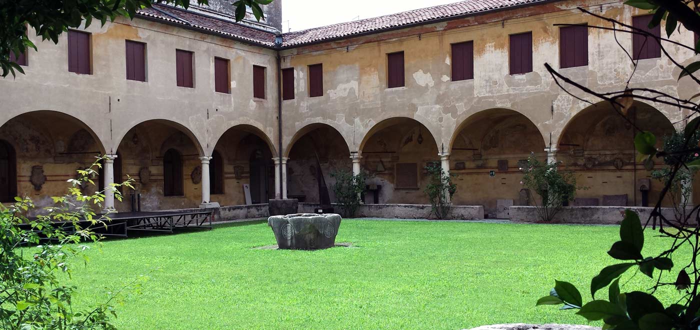 A cloister with a large green lawn in the center