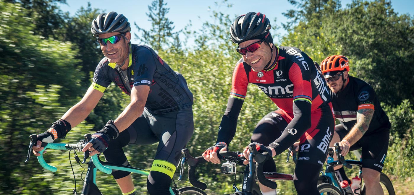 Smiling friends doing a road bike ride