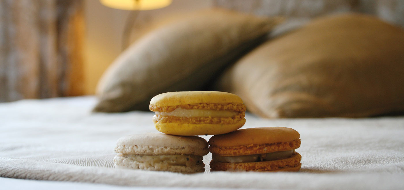 Three delicious macarons on the bed of a hotel room near Monte Grappa