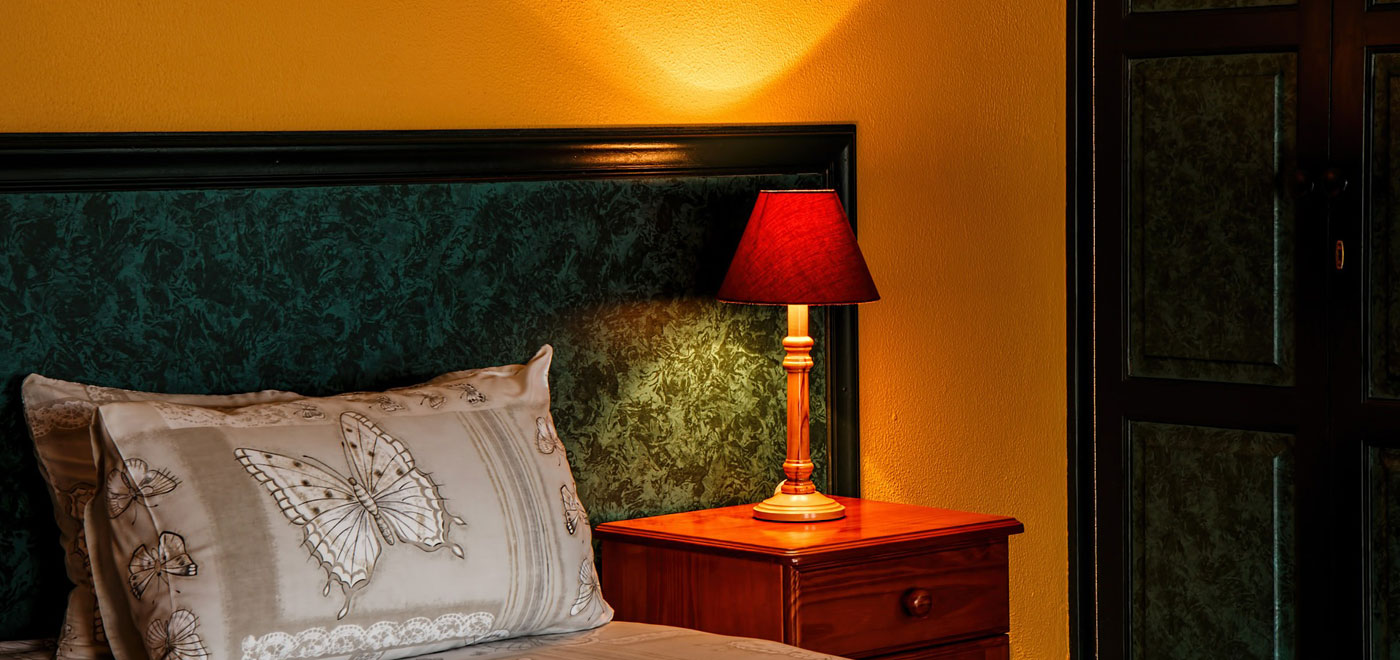 A bed pillow with butterfly design on a hotel room