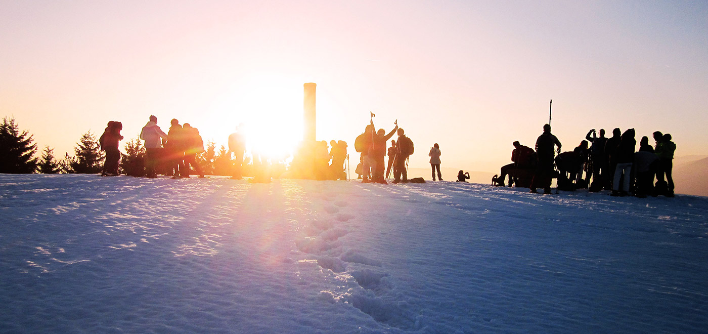 friends talking on the snow after skiing at sunset