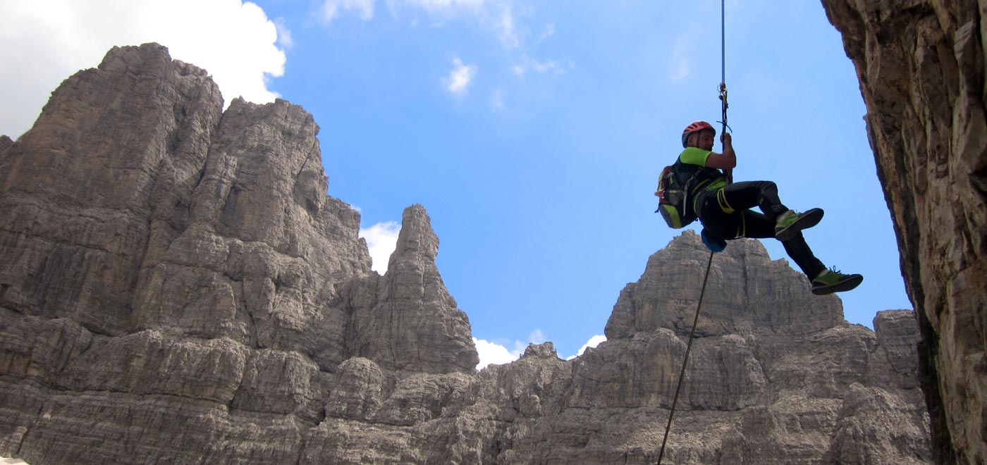 scalatore che si cala dopo un'arrampicata sulle Dolomiti venete
