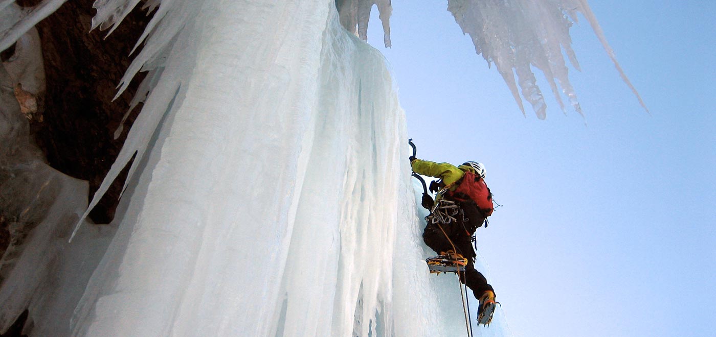 A climber climbs on an icy waterfall