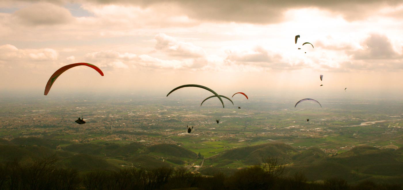 alcune persone volano in parapendio nei cieli intorno al Monte Grappa